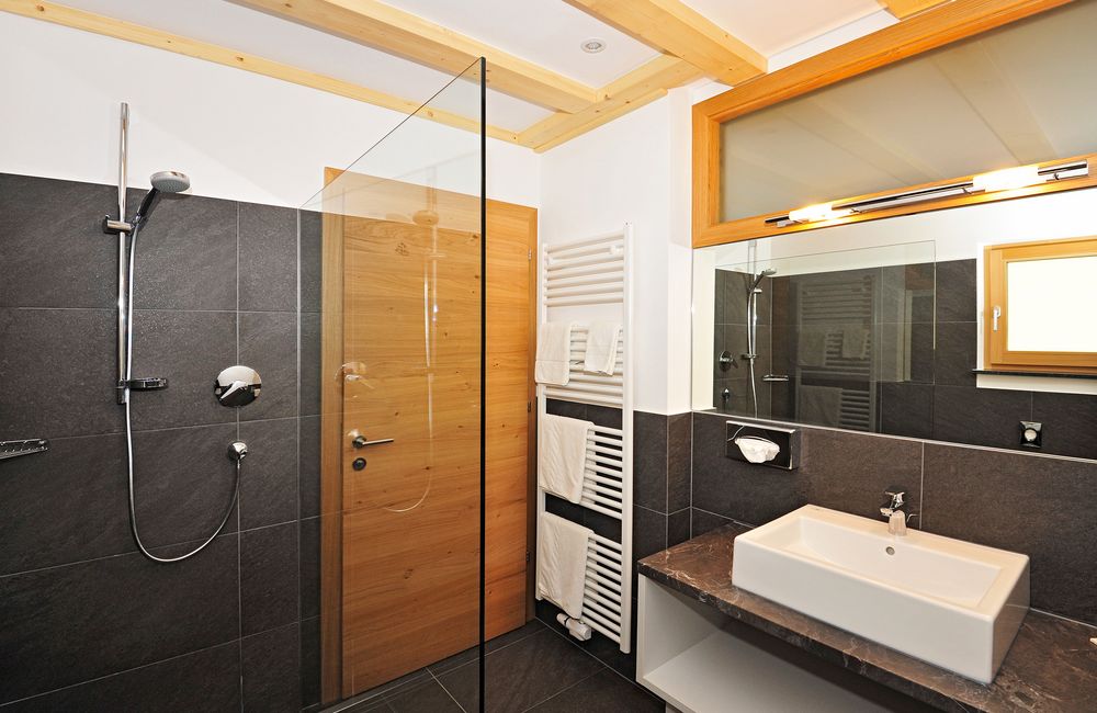 Modernes Badezimmer mit Dusche, Waschbecken und Handtuchheizkörper