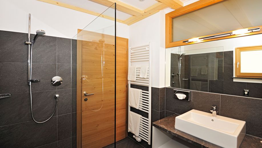 Modernes Badezimmer mit Dusche, Waschbecken und Handtuchheizkörper