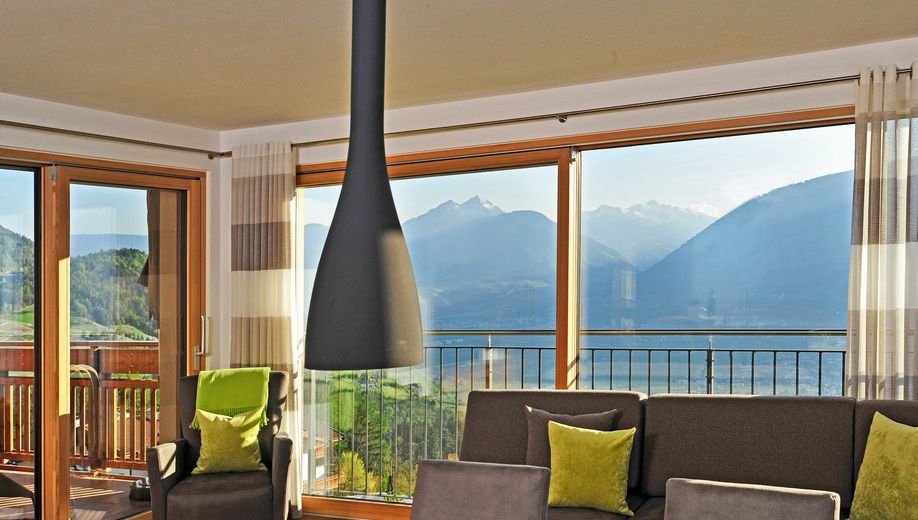 Wohnzimmer mit Aussicht auf Berge und See durch große Fenster