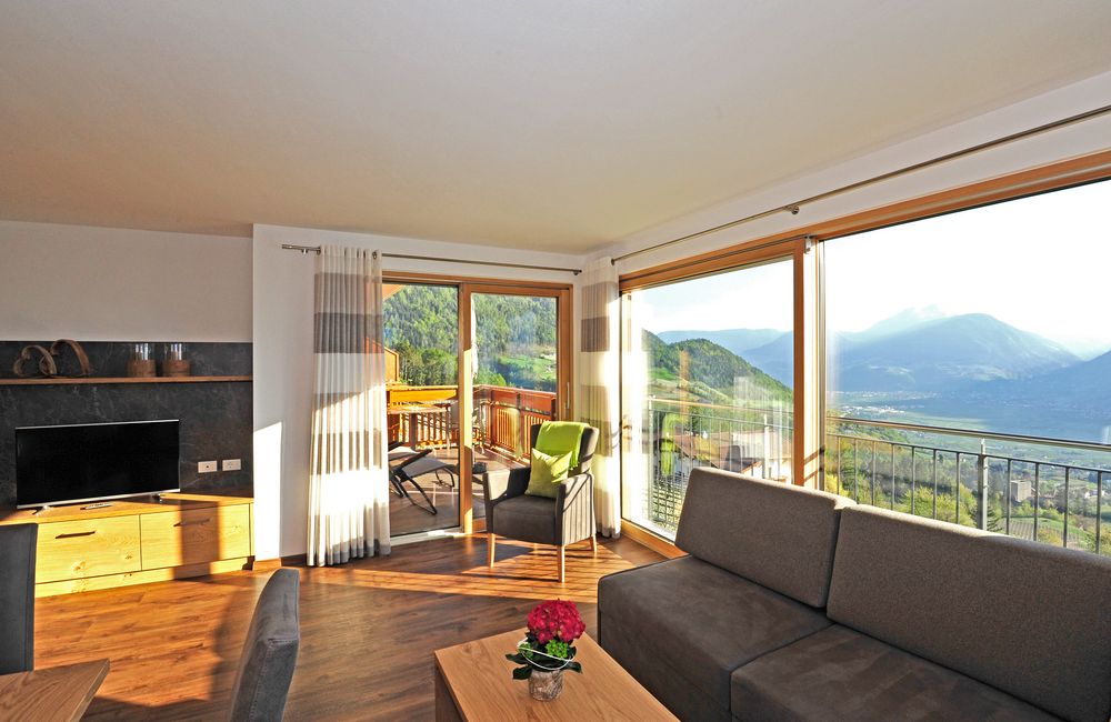 Helles Wohnzimmer mit großen Fenstern und Bergblick.