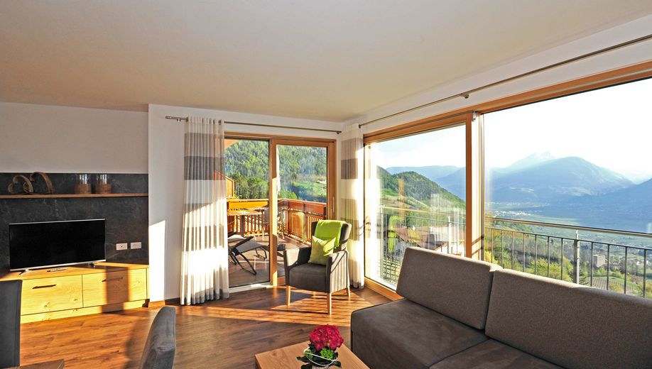 Helles Wohnzimmer mit großen Fenstern und Bergblick.