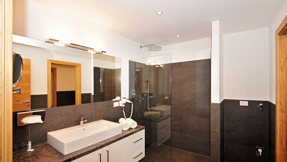 Modernes Badezimmer mit Waschbecken, Spiegel und begehbarer Dusche